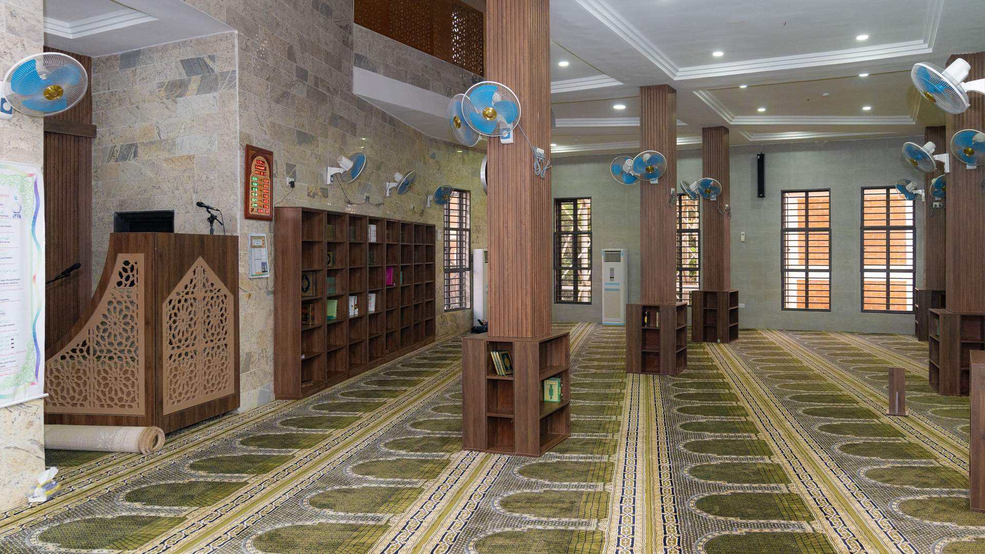 Interior of the main prayer hall with minbar and Quran library